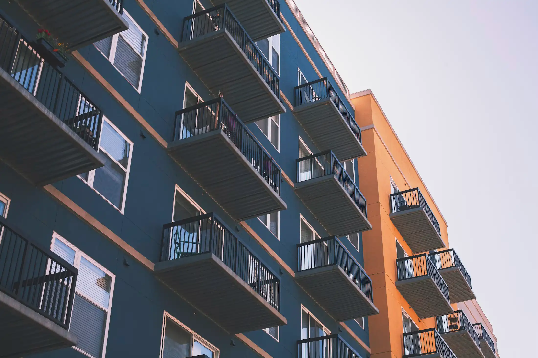 The facade of an apartment building with balconies, seen from below