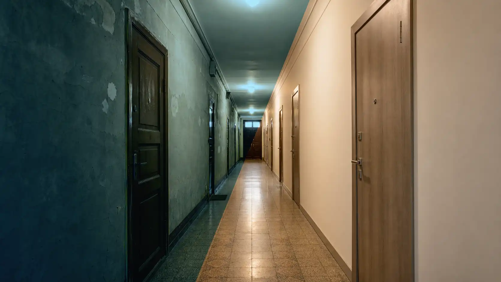 An apartment building corridor before and after renovation — the dark old finish next to the light new one